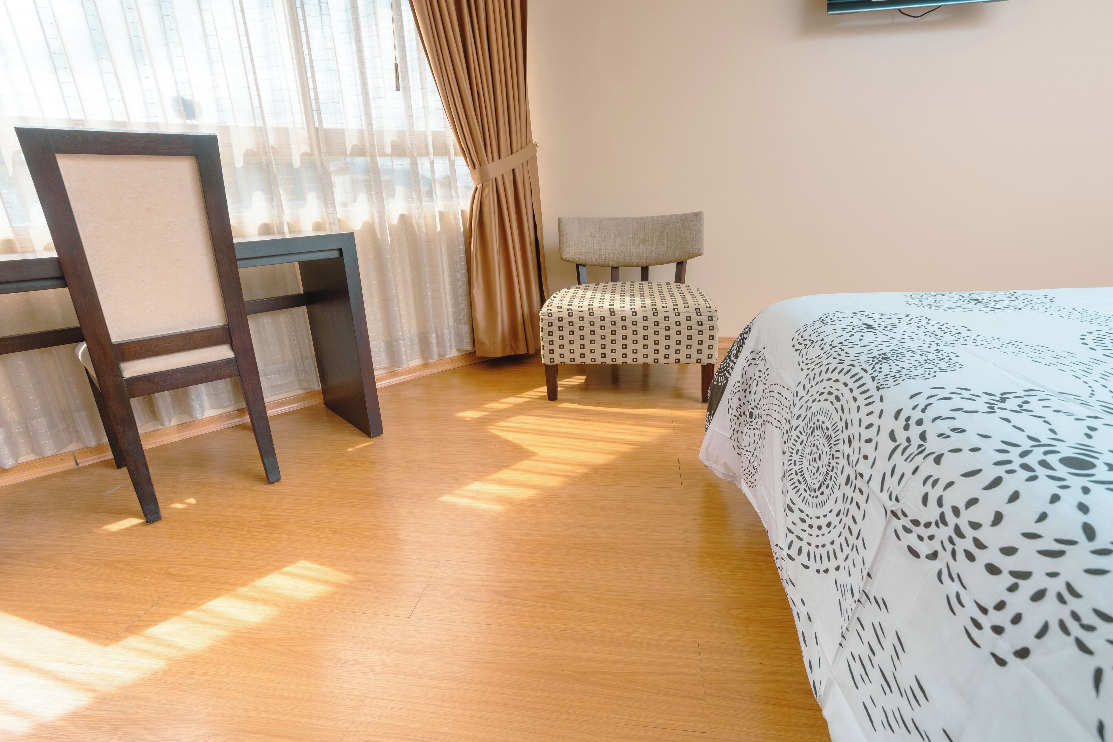 A room with a bed, a desk, and a chair.