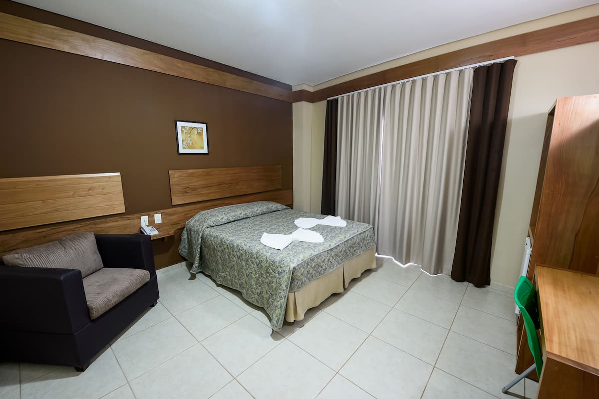 Una habitación de hotel con cama, sofá, escritorio y silla.