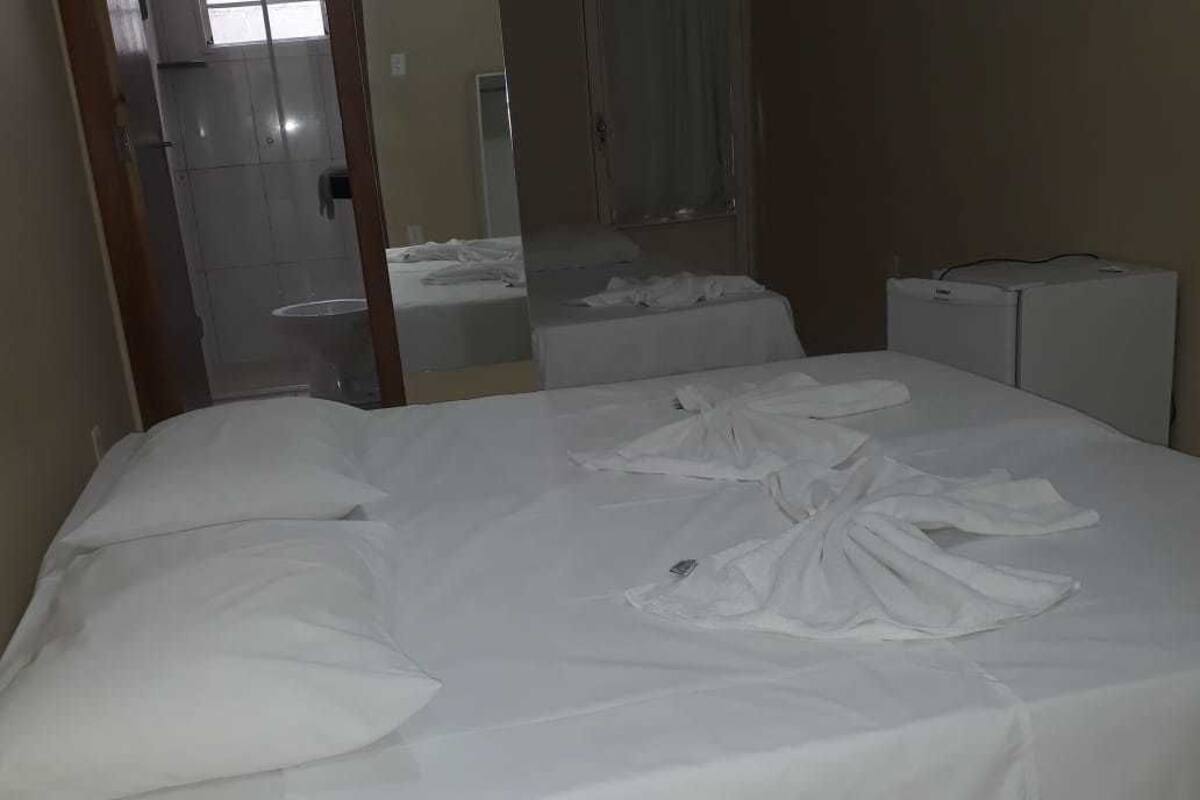 Ein Hotelzimmer mit einem Bett, einem kleinen Tisch und einem Spiegel.