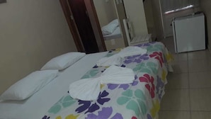 A room with two beds, each with a colorful floral bedspread and white pillows. - Pousada Estrela do Vale (Taubate)