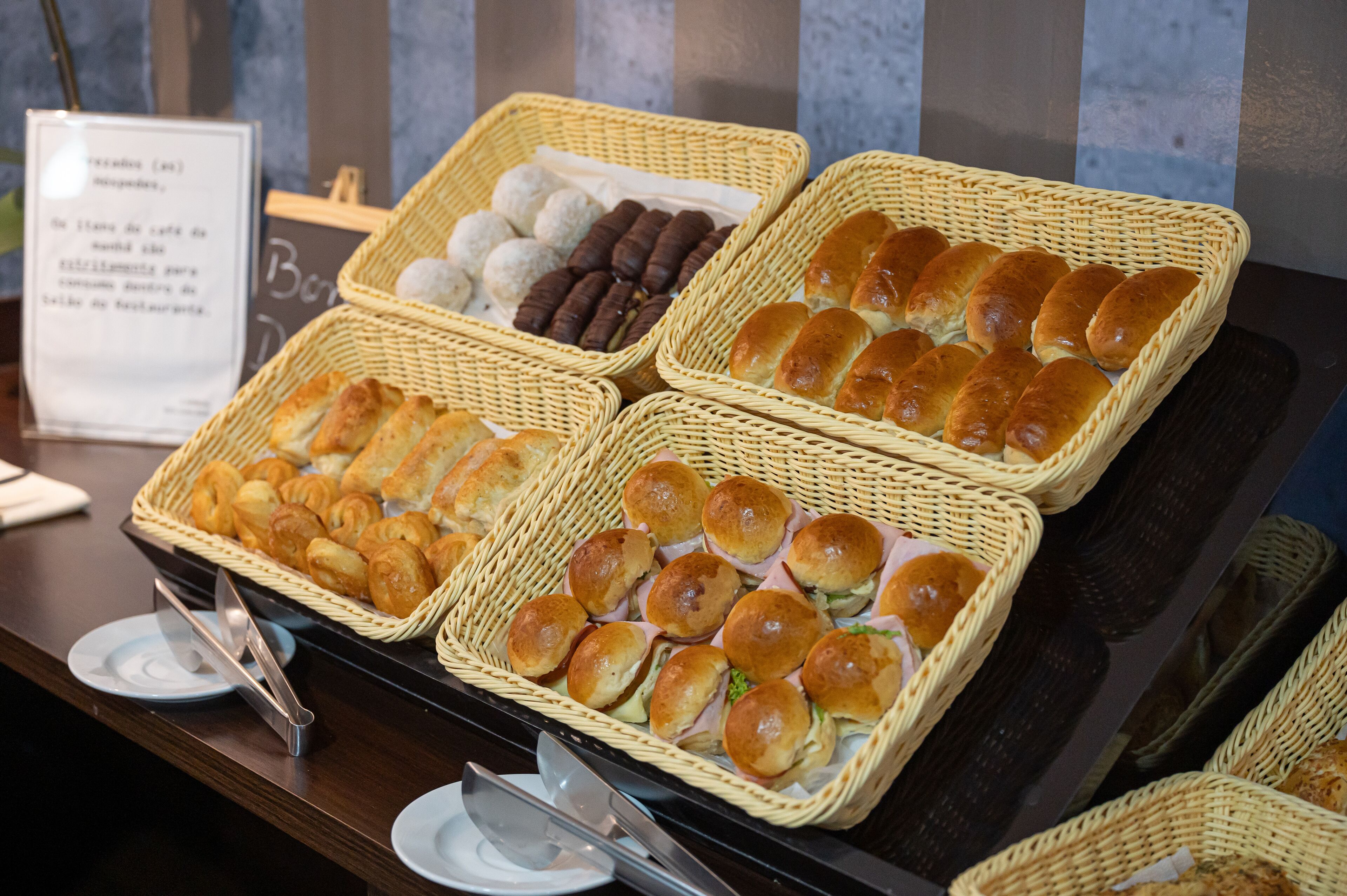 Un buffet proposant une variété de produits de boulangerie, notamment des petits pains, des croissants et des pâtisseries.