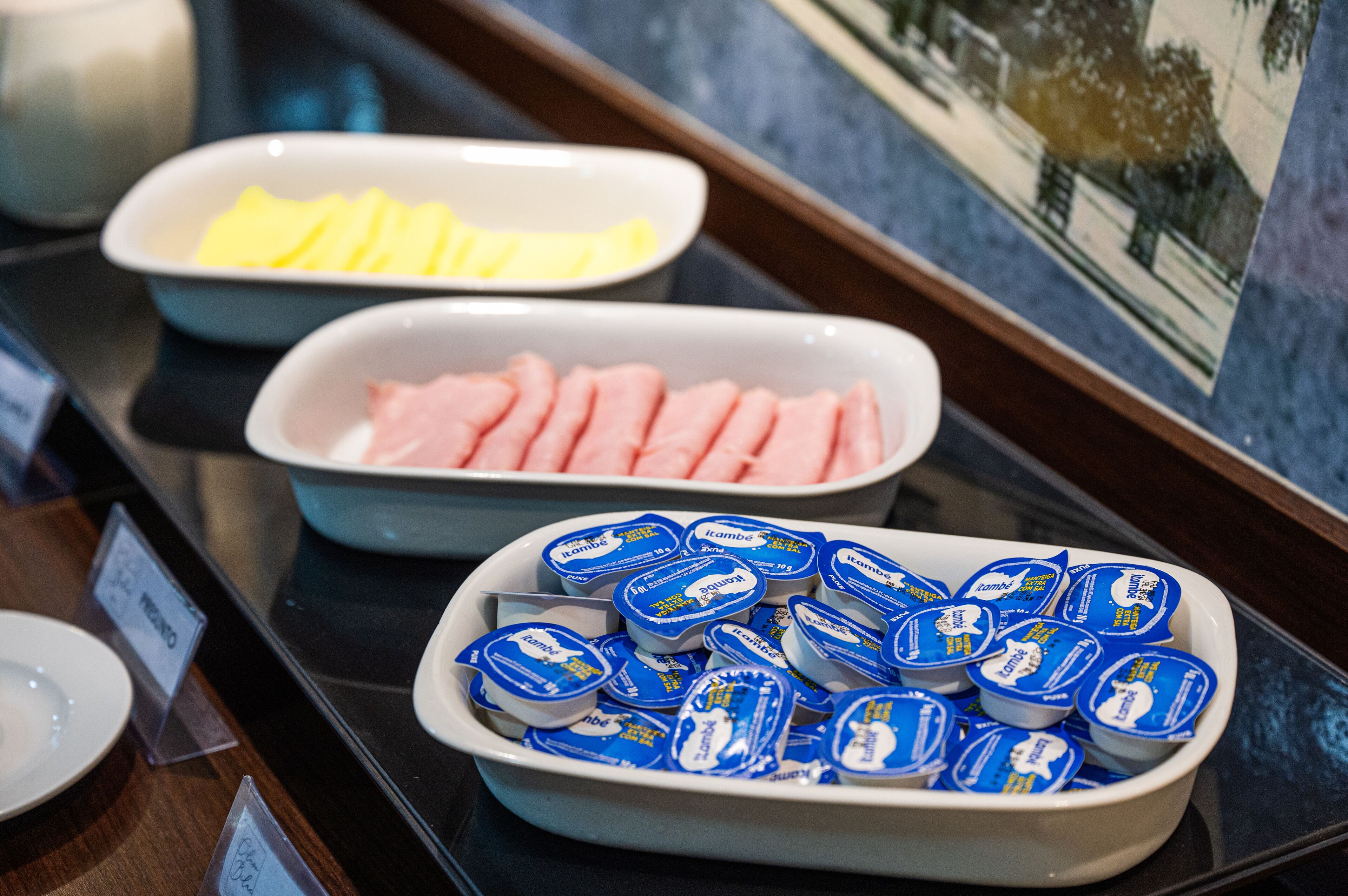 A buffet with various food items including sliced fruits, meats, and packaged desserts.