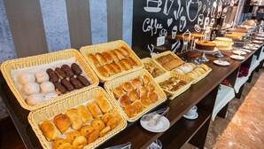Una mesa de buffet con diversos productos horneados y pasteles.