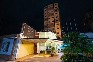 A hotel with a curved facade, large windows, and a sign reading "Flat Hotel." - Olavo Bilac Hotel (Taubate)