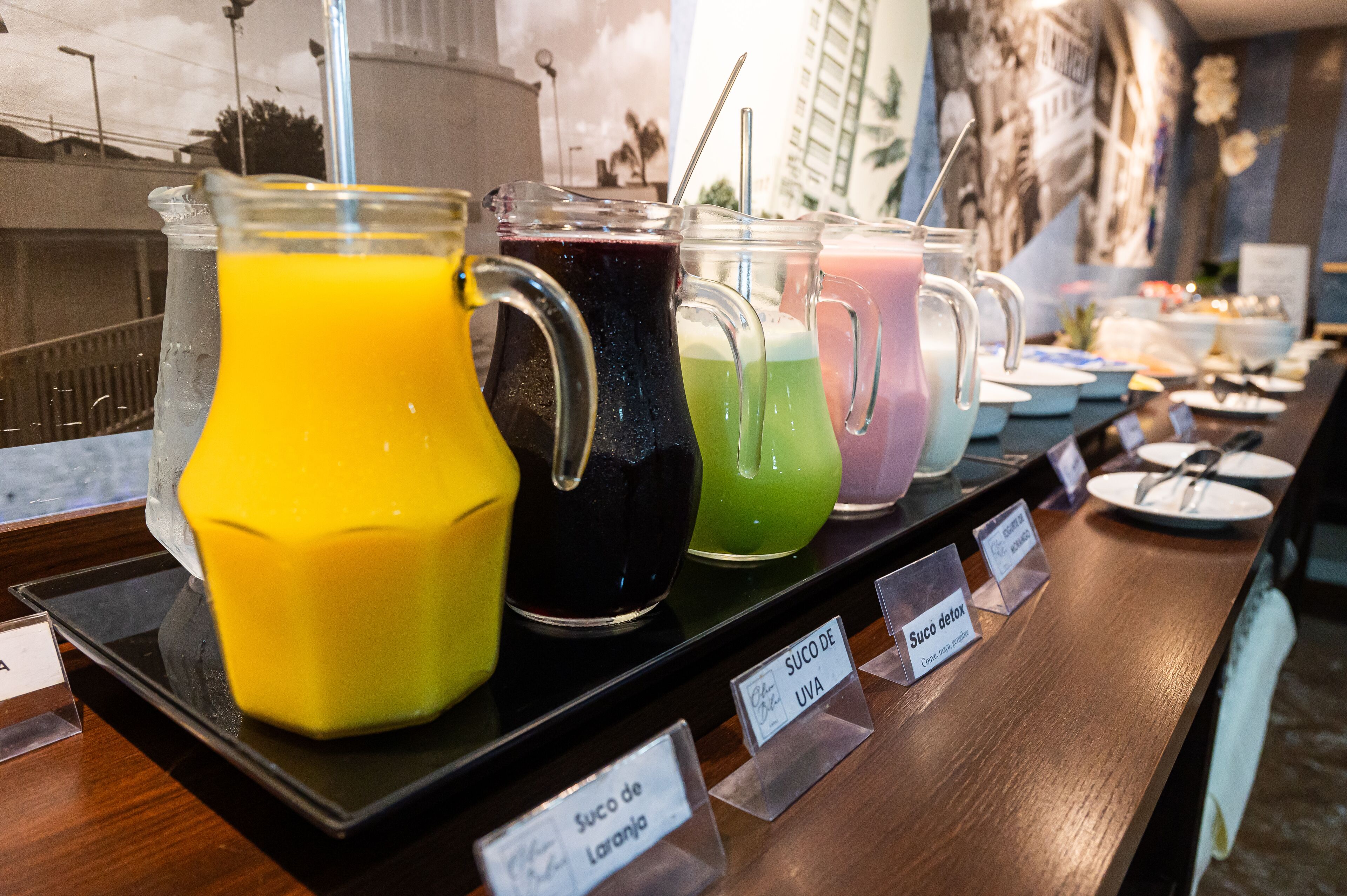 A buffet with various fruit juices and labeled drink options.