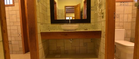 A bathroom with a sink, mirror, and toilet.