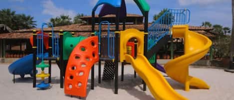 A playground with multiple slides and climbing structures.