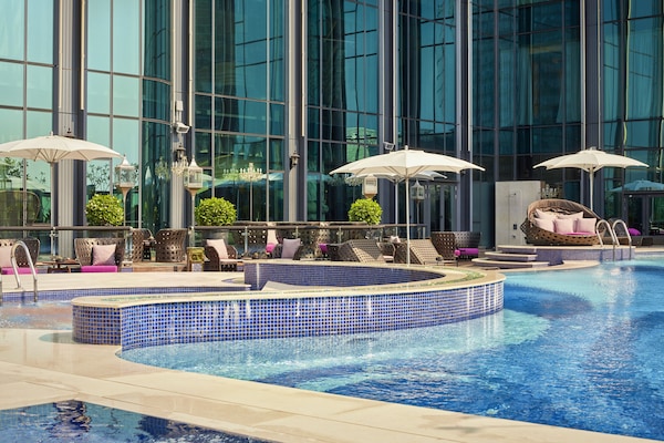 Alberca al aire libre, sombrillas en la alberca y camastros