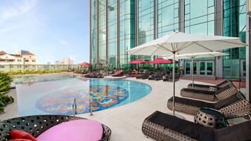 Een buitenzwembad, parasols voor strand/zwembad