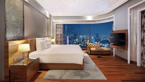 A modern hotel room with a large bed, a TV, and a city view. - The Reverie Saigon Residential Suites (Ho Chi Minh City)
