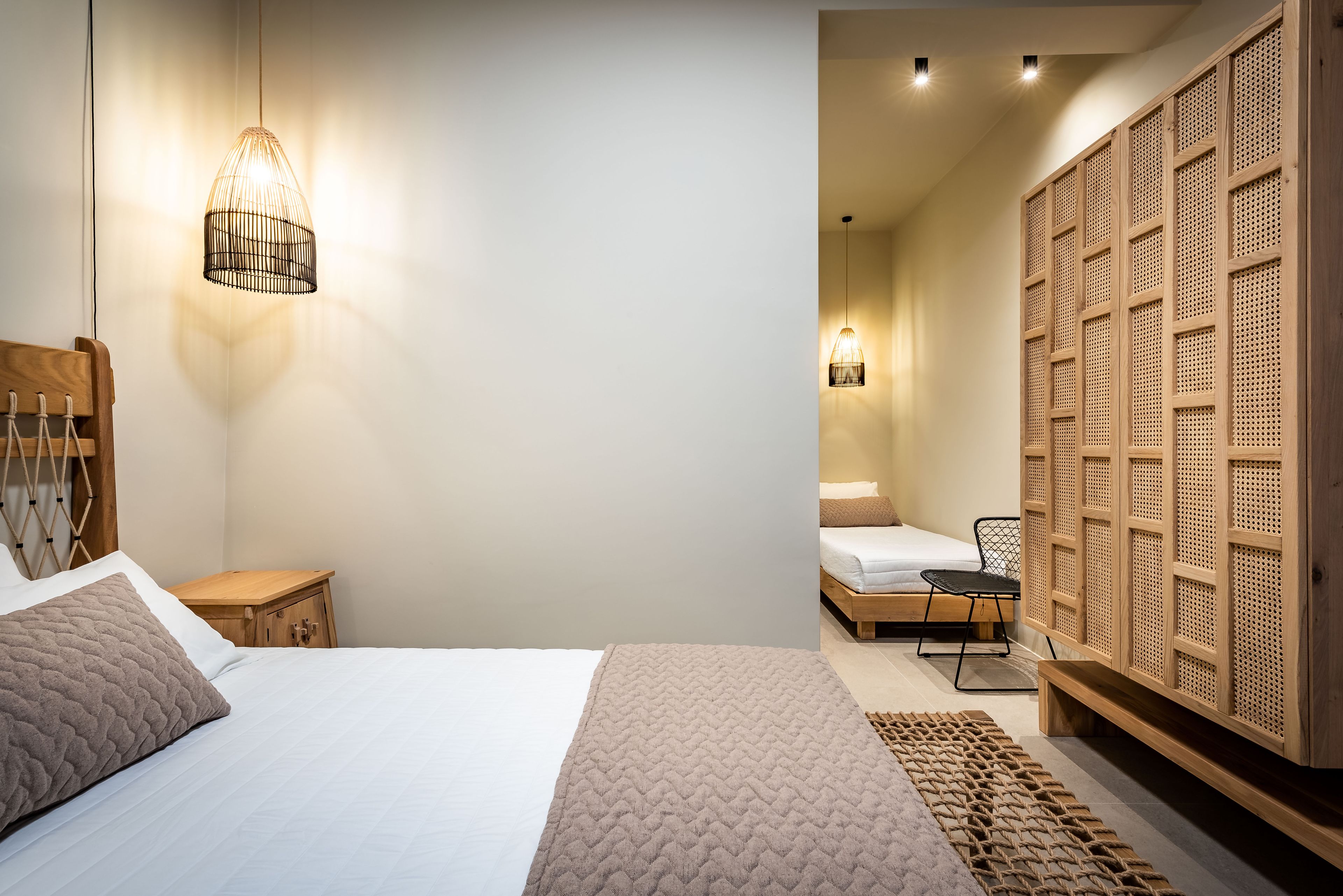 Une chambre à coucher moderne avec un lit, une table de chevet et un luminaire suspendu.