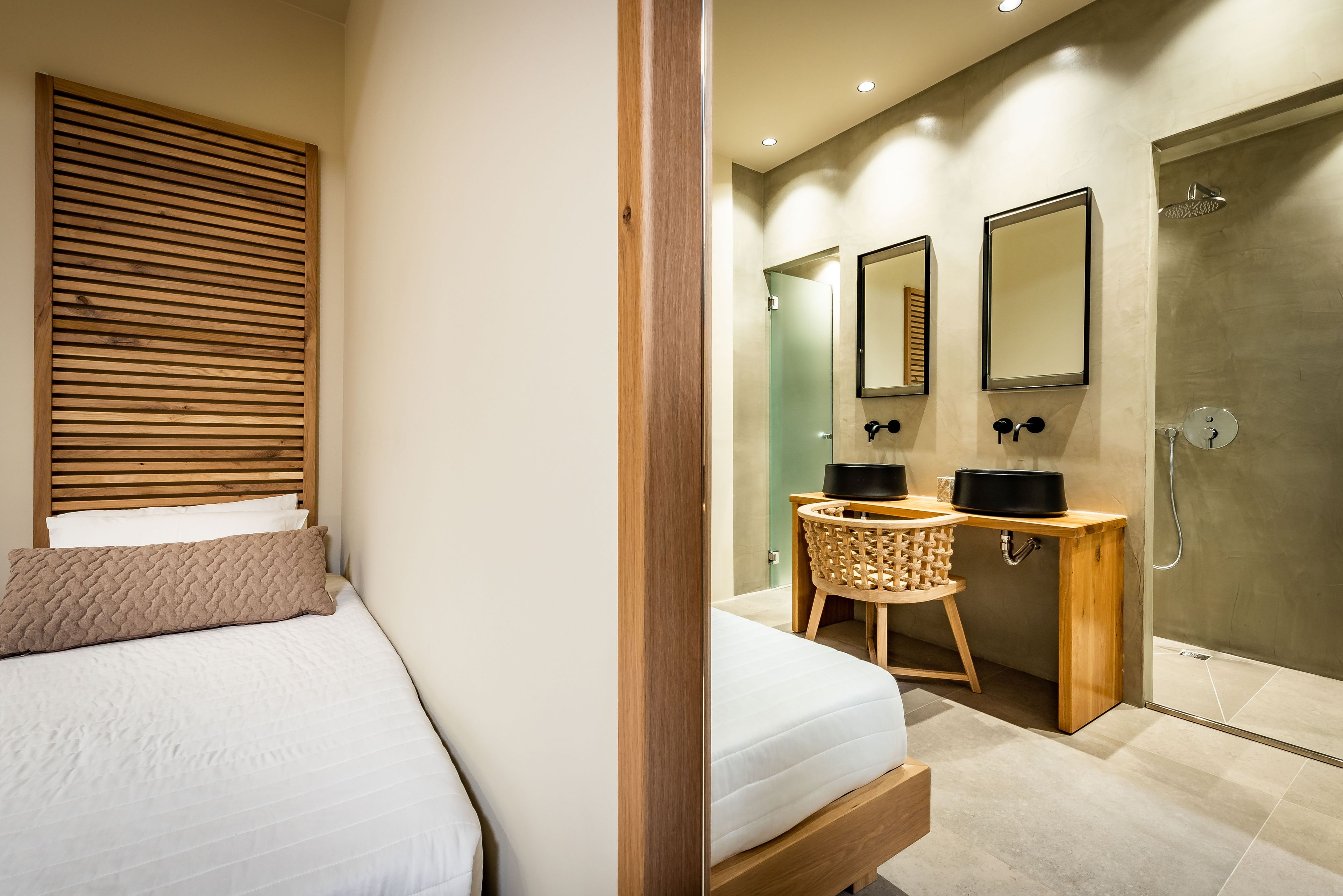 Un dormitorio con una cama, cabecera de madera y mesita de noche con lámpara.