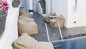 Zona piscina con area relax e scalinata che conduce a un livello superiore.