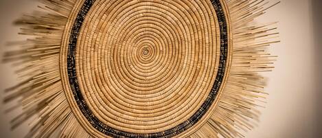 A circular woven wall hanging with concentric circles and a central point.