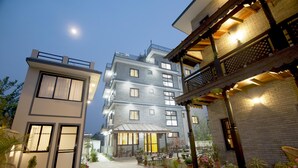 A multi-story hotel with a modern design, featuring a well-lit entrance and a balcony with a railing. - Hotel Utsab Himalaya (Pokhara)
