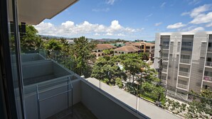 Een balkon met vrij uitzicht op omliggende gebouwen en groen.