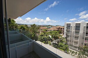 Un balcon offrant une vue dégagée sur les bâtiments et la végétation environnants.