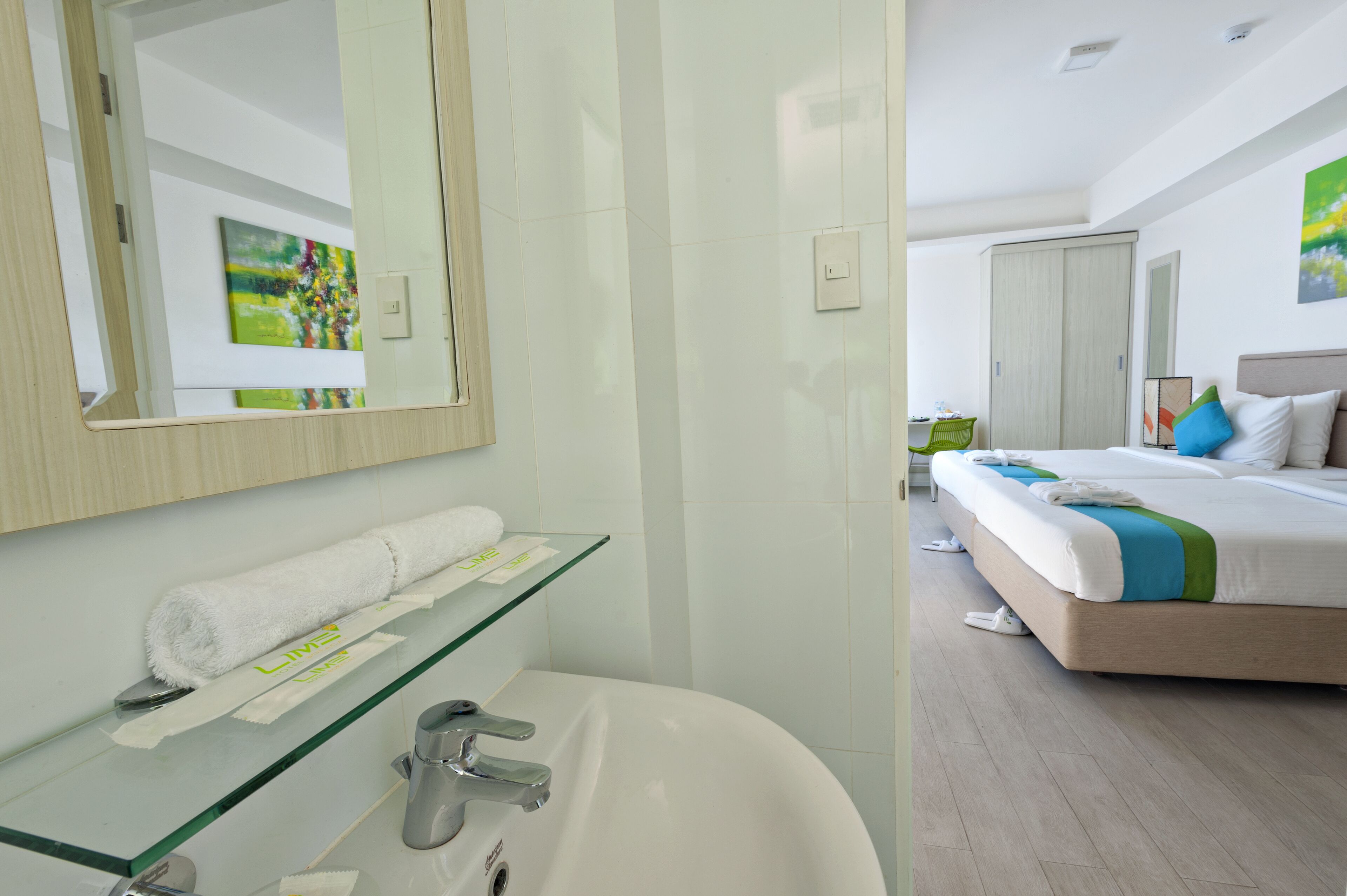 A modern bathroom with a glass shelf, a white sink, and a large mirror.