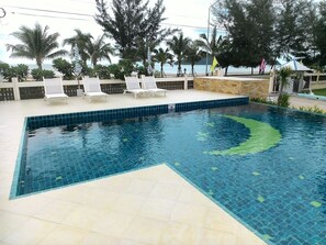 Una piscina al aire libre, tumbonas