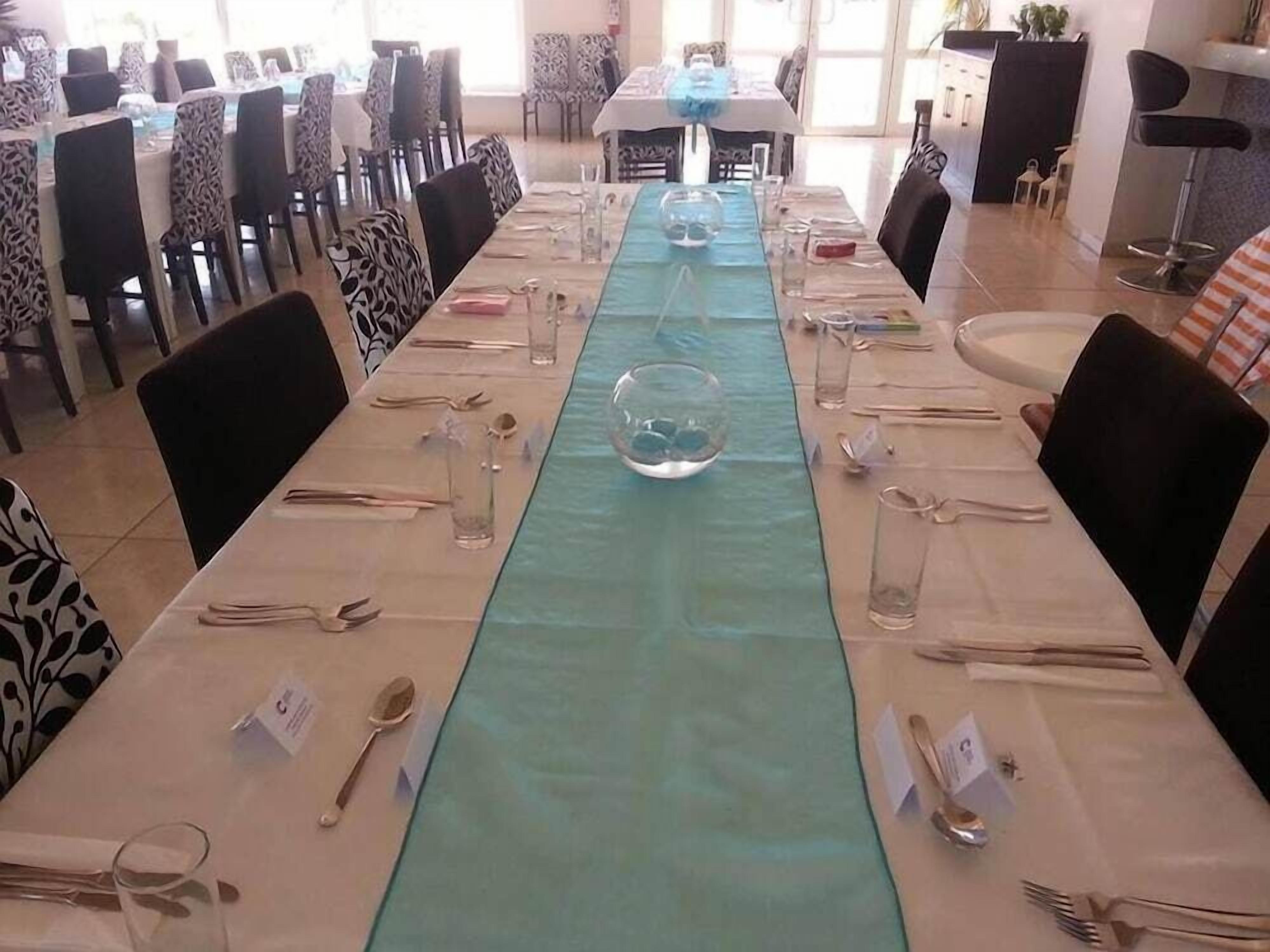 Un comedor con mesas dispuestas para el servicio, sillas con tapicería estampada y vista al interior de la habitación.
