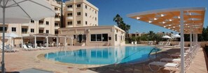 Una piscina al aire libre, sillones reclinables de piscina
