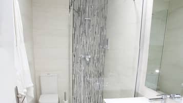 Suite estudio urbana, 1 cama Queen size y sofá cama, vista al parque | Baño | Regadera, amenidades de baño gratuitas, secadora de cabello, toallas