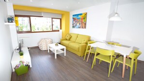 A modern living room with a yellow sofa, white coffee table, and yellow chairs around a white table. - Color Suites Alicante (Alicante)