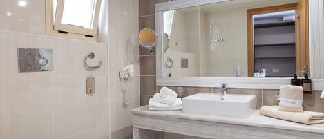 A modern bathroom with a toilet, a sink with a mirror above it, and a towel rack.