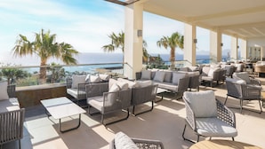 A rooftop terrace with outdoor seating, a pool, and a view of the sea. - Grand Blue Beach Hotel (Kos)