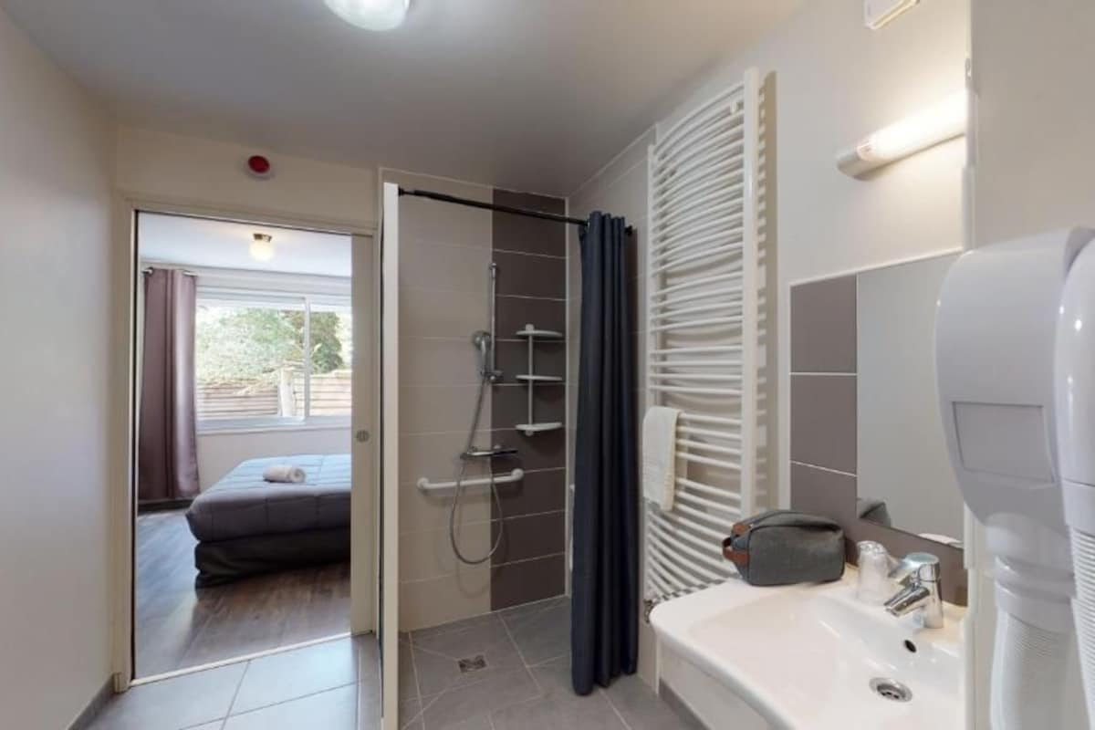 Un baño moderno con ducha, bañera, inodoro y lavamanos.