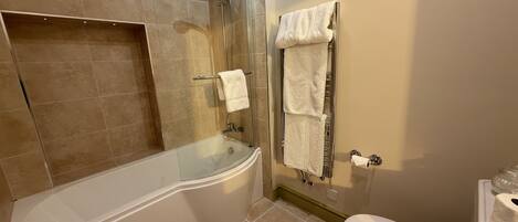 A bathroom with a bathtub, a shower, a toilet, and a towel rack.