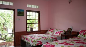 A bedroom with two beds, a balcony, and a large window. - Minh Anh Garden Hotel (Phan Thiet)