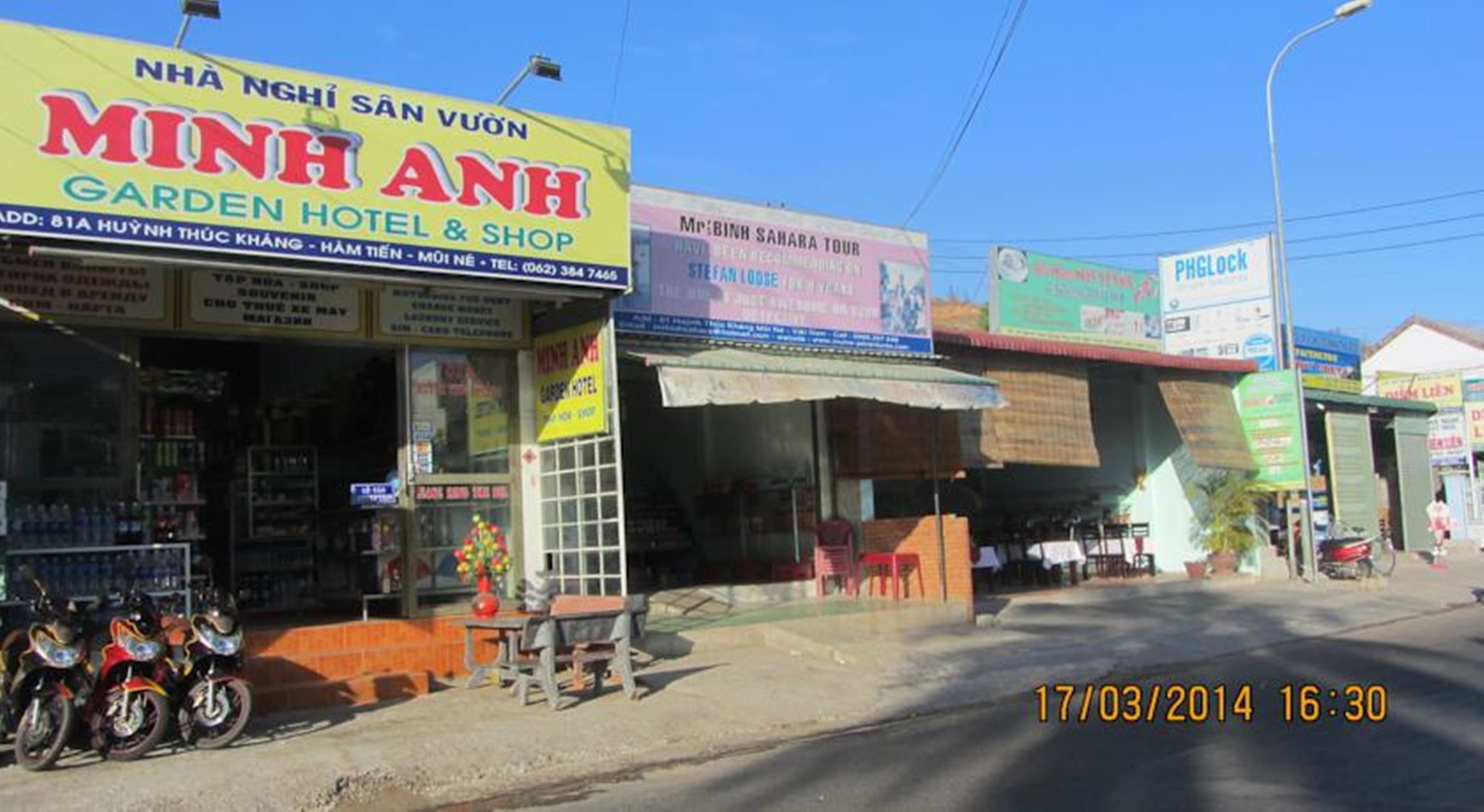 Straßenansicht mit dem Hotel 'Minh Anh Garden Hotel & Shop' und einem draußen abgestellten Motorrad.