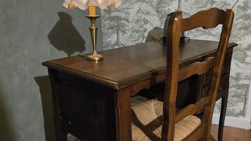 Una mesa de madera para comer con una lámpara y una silla.