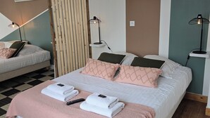 Ein modernes Schlafzimmer mit einem großen Bett, zwei Nachttischen, einer Hängeleuchte und einem an der Wand montierten Regal.