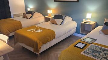 A hotel room with two beds, a desk, and a framed picture on the wall.