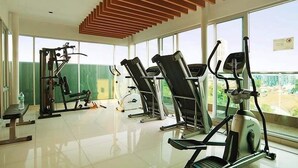 A gym with various exercise equipment, large windows, and a modern ceiling design. - The Gallery Jomtien Beach Pattaya Condo By Dome (Pattaya)