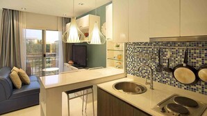 A modern kitchen with a central island, a built-in sink, and a backsplash with blue and white tiles. - The Gallery Jomtien Beach Pattaya Condo By Dome (Pattaya)