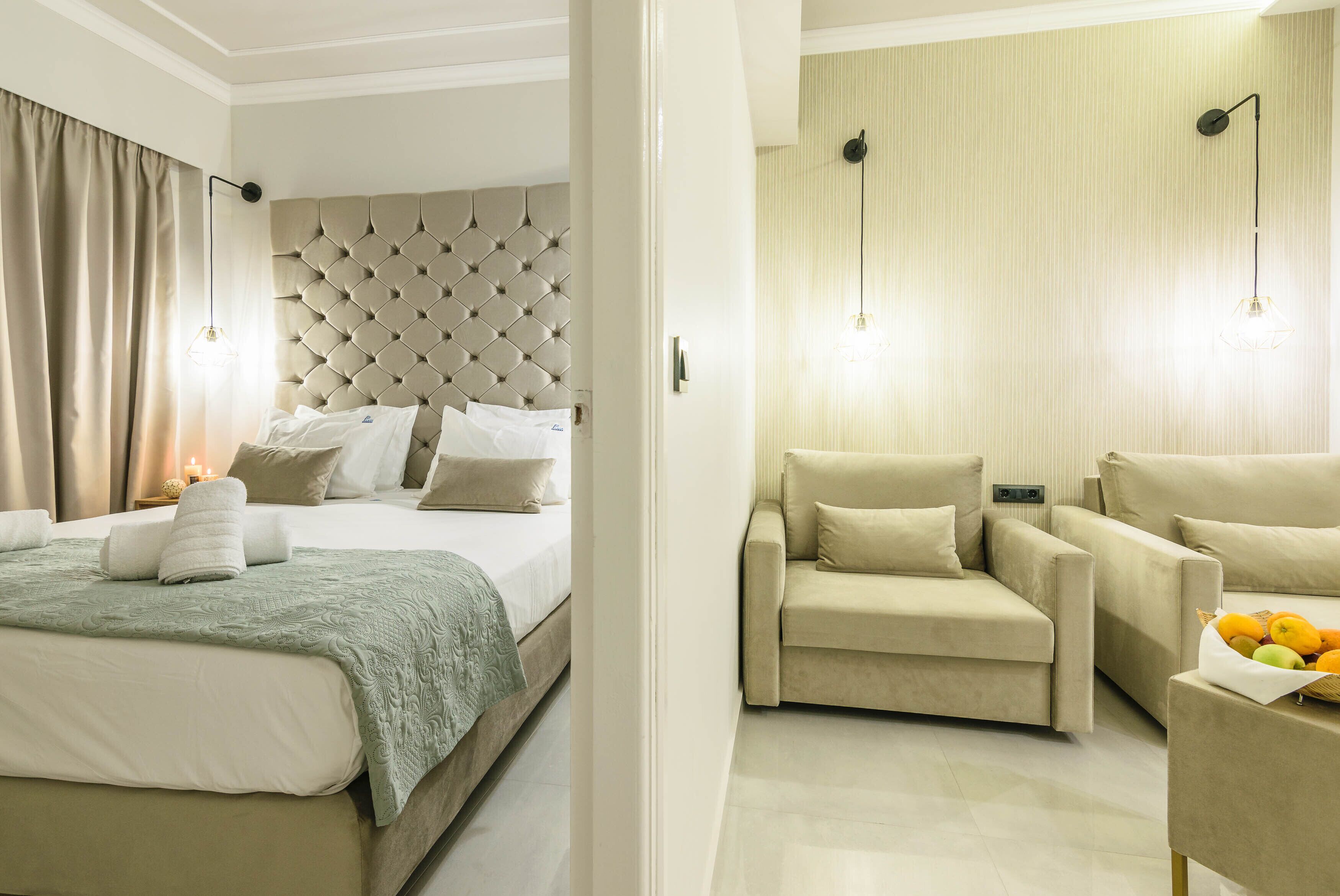 Een hotelkamer met een groot bed, een bank en een kleine tafel met fruit.