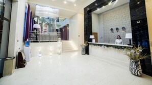 A hotel lobby with a reception desk, a staircase, and a chandelier. - Absolute Hotel (Astana)