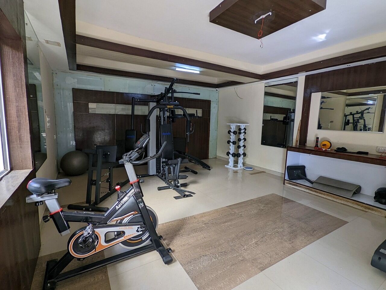A home gym with exercise equipment including a stationary bike, a treadmill, and weight machines.