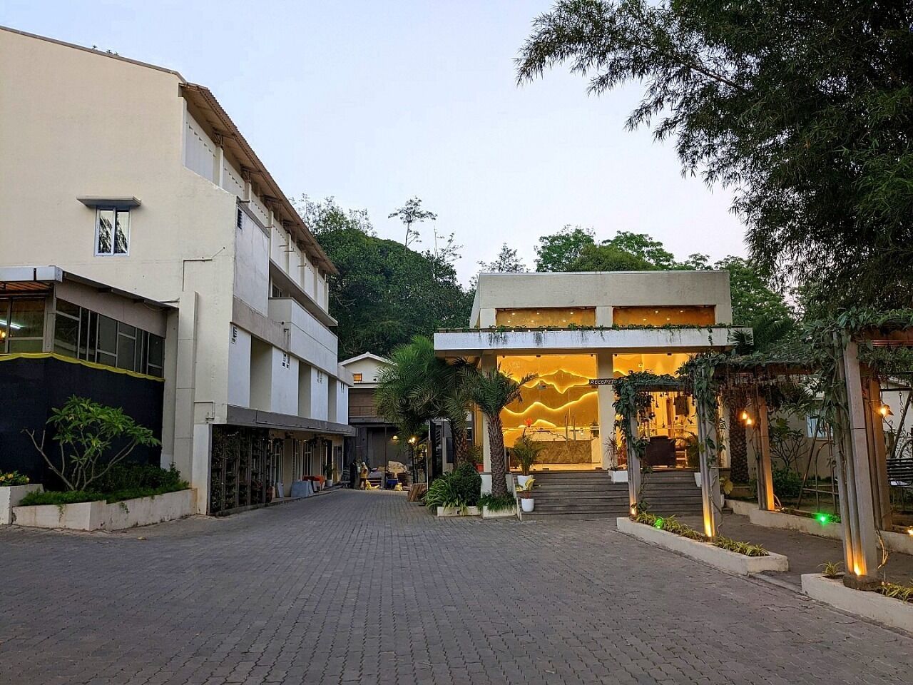 Una entrada de hotel con diseño moderno, que destaca un arco acogedor y una fachada bien iluminada.