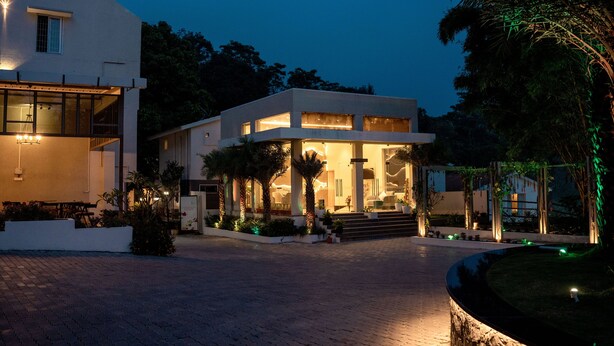 A modern building with a central courtyard, featuring a covered seating area and a staircase leading to the entrance. - TGI STAR Holidays Yercaud (Yercaud)