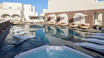 Una piscina al aire libre de temporada, sombrillas