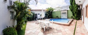 Una piscina al aire libre, sillones reclinables de piscina