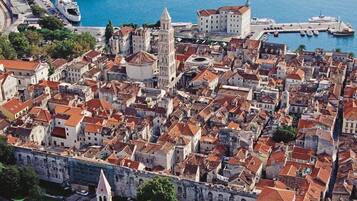 Un área urbana densamente poblada con edificios históricos, una iglesia destacada y un frente marítimo con barcos.