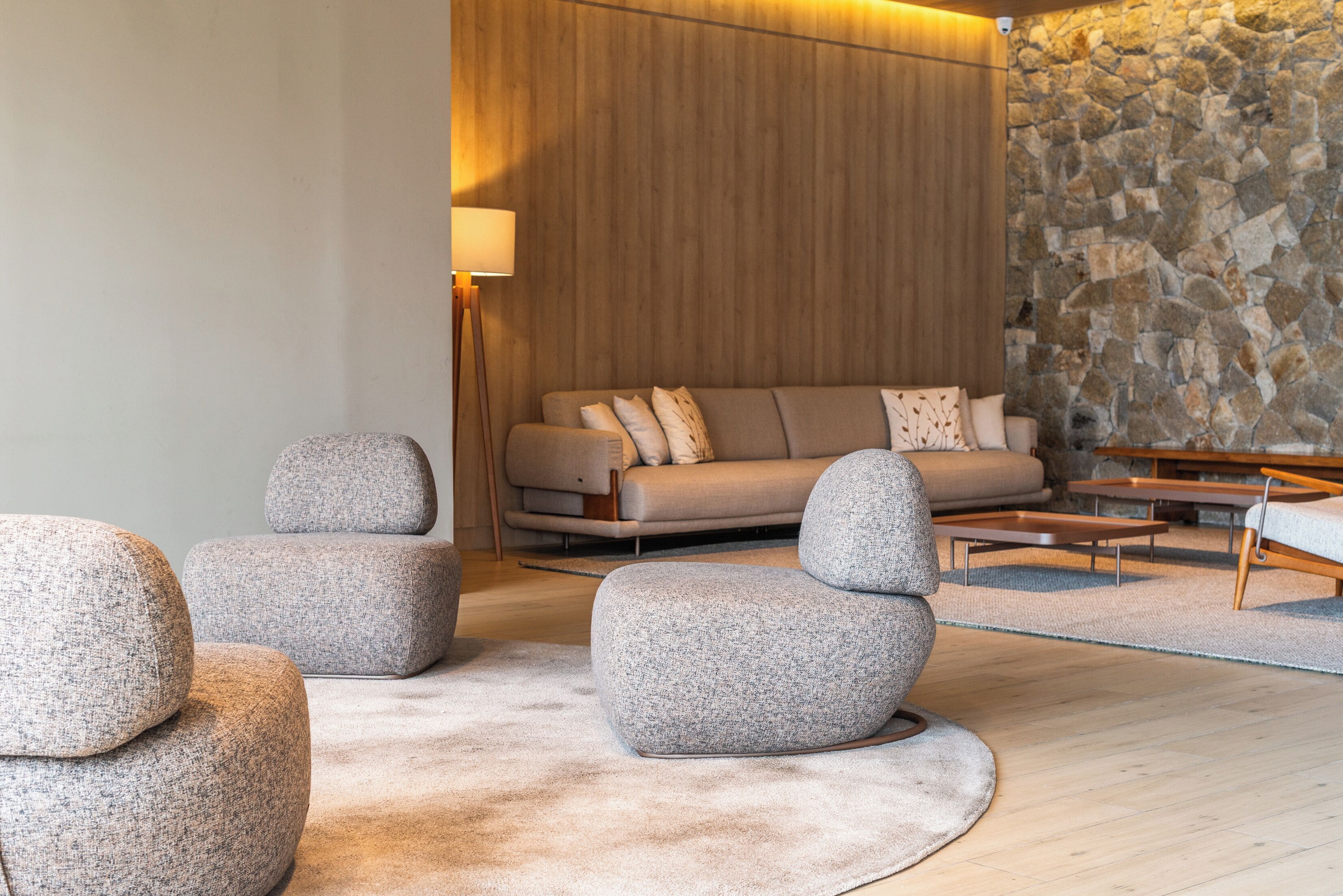 Un salon moderne avec un canapé, des poufs et une table basse.