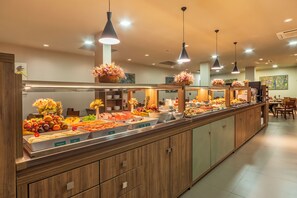 Un esmorzar buffet amb diversos plats i un taulell de fusta.