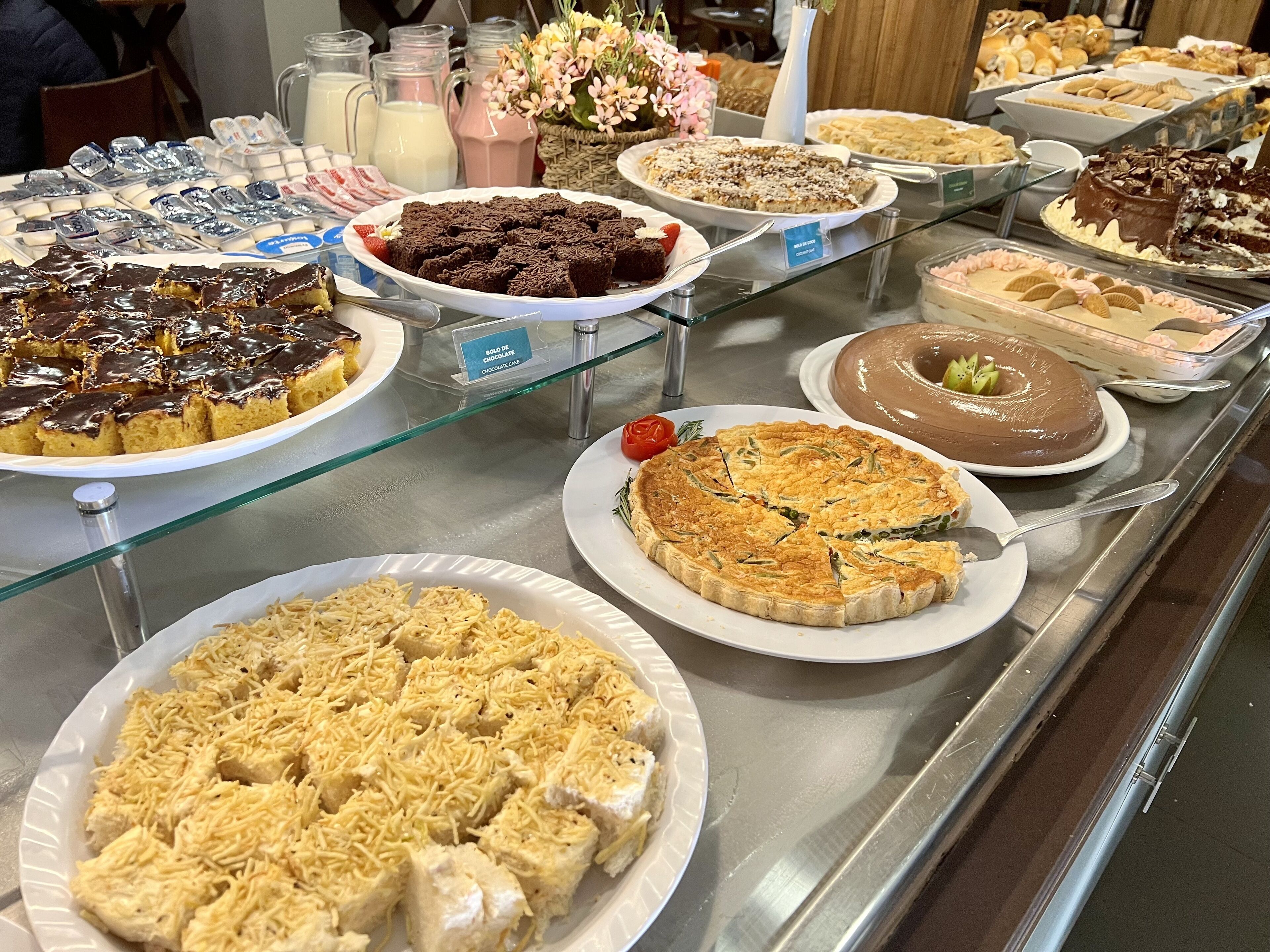 A variety of desserts displayed on a glass counter.