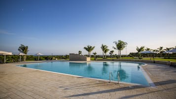 Piscine extérieure, parasols de plage, chaises longues